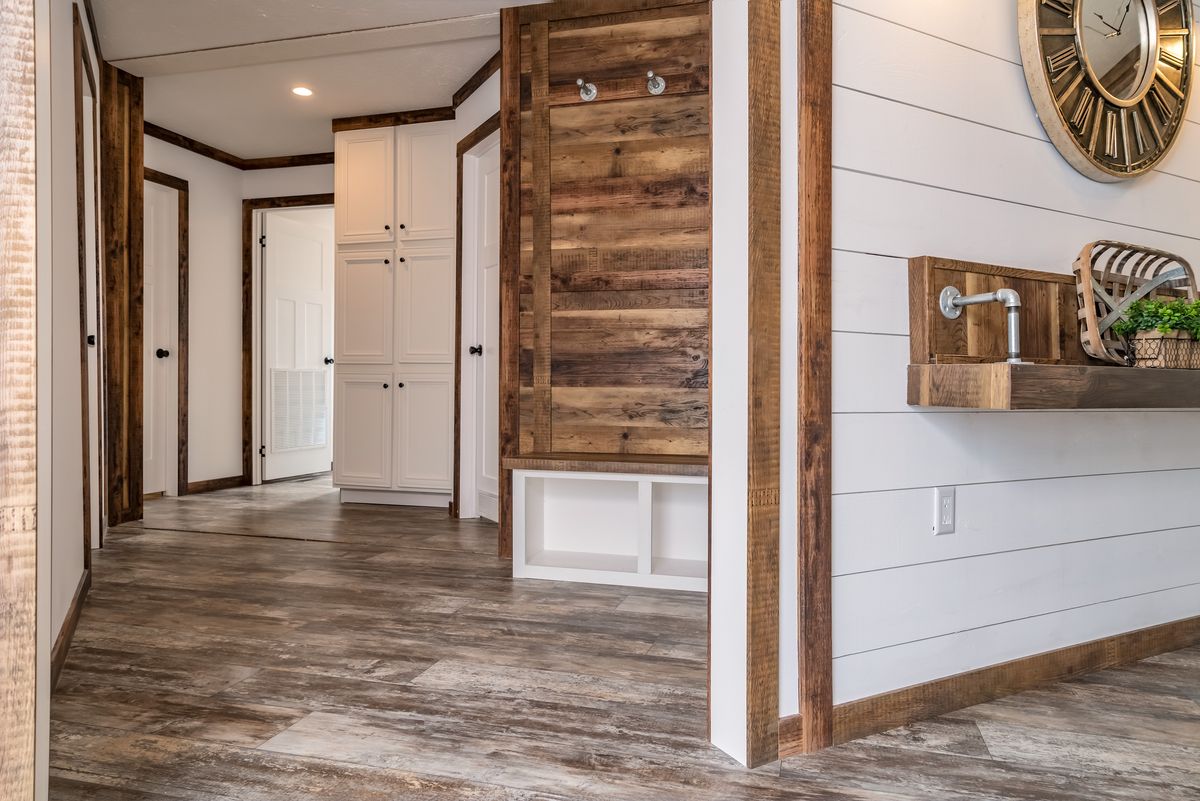 A hallway with wood paneling and a mirror.