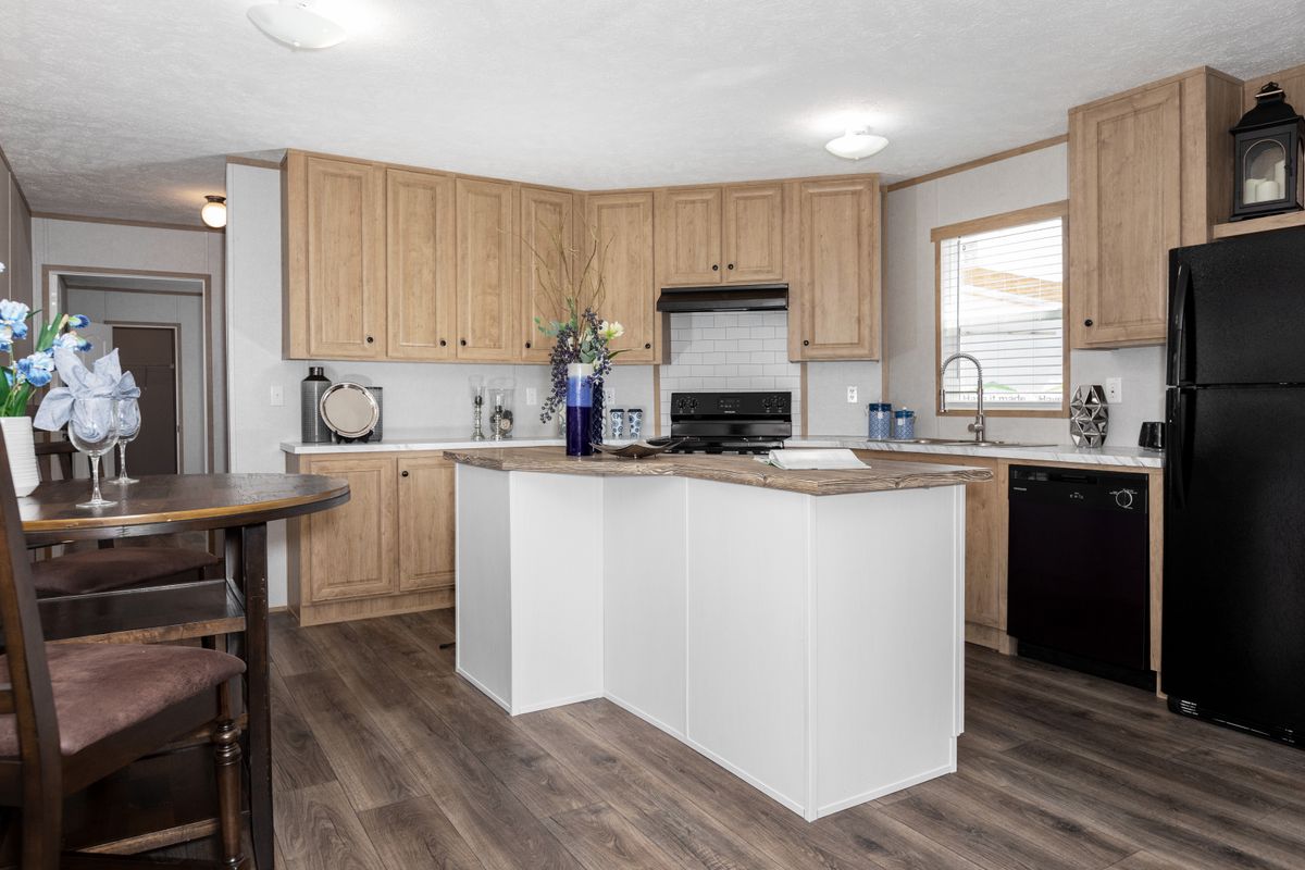 51bbfff2-547e-4928-a69e-0761d0441c9b A kitchen in a mobile home with hardwood floors.