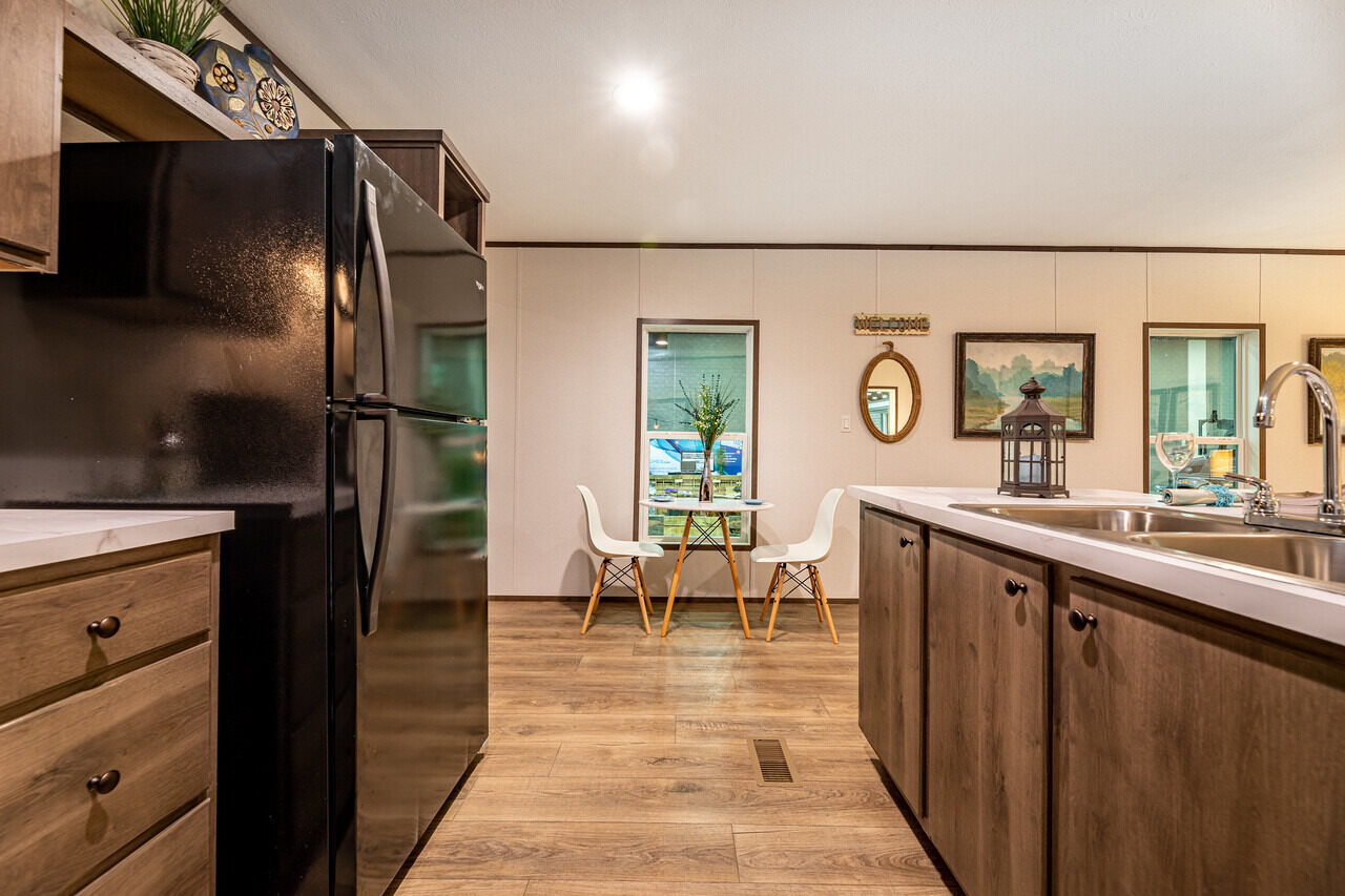 52634728154_ccc272eb2c_k_1_1677195218177_1681335809826_1683655207767_1280_12 A kitchen in a mobile home with wood floors.