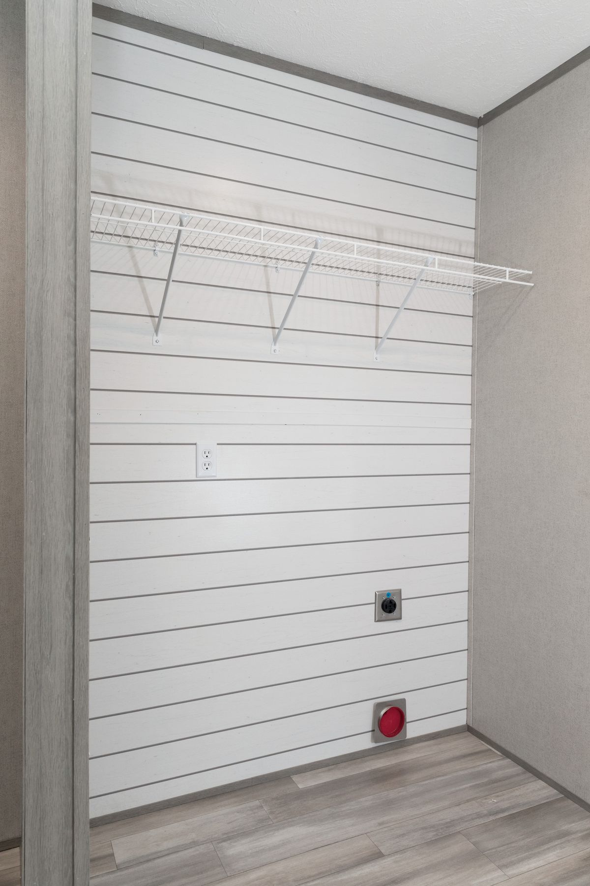 52b4e5c4-c05a-4dfd-9a78-c137285d7052 A small room with white walls and a wooden floor.
