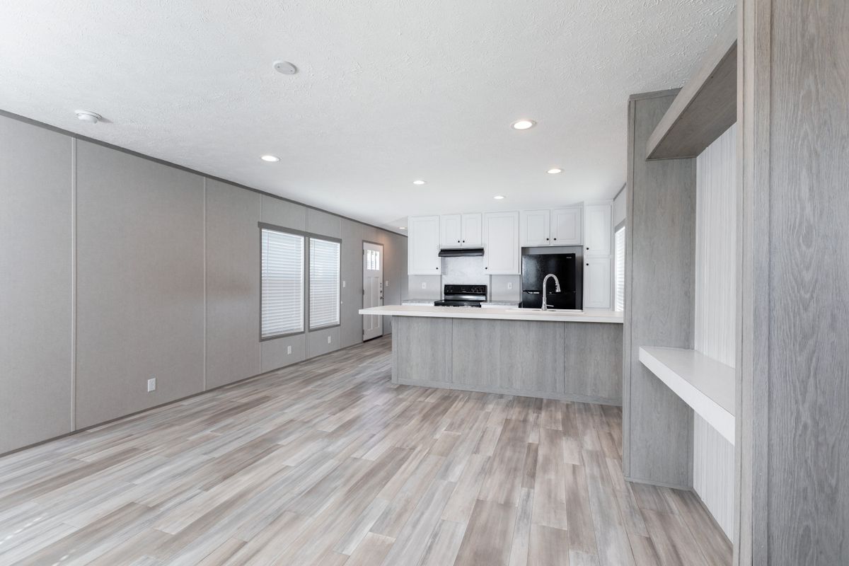5405114b-ca66-4c8a-a08f-94e213f99feb A kitchen and living room in a mobile home.