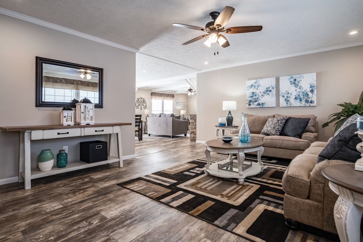 A living room with hardwood floors and a ceiling fan.