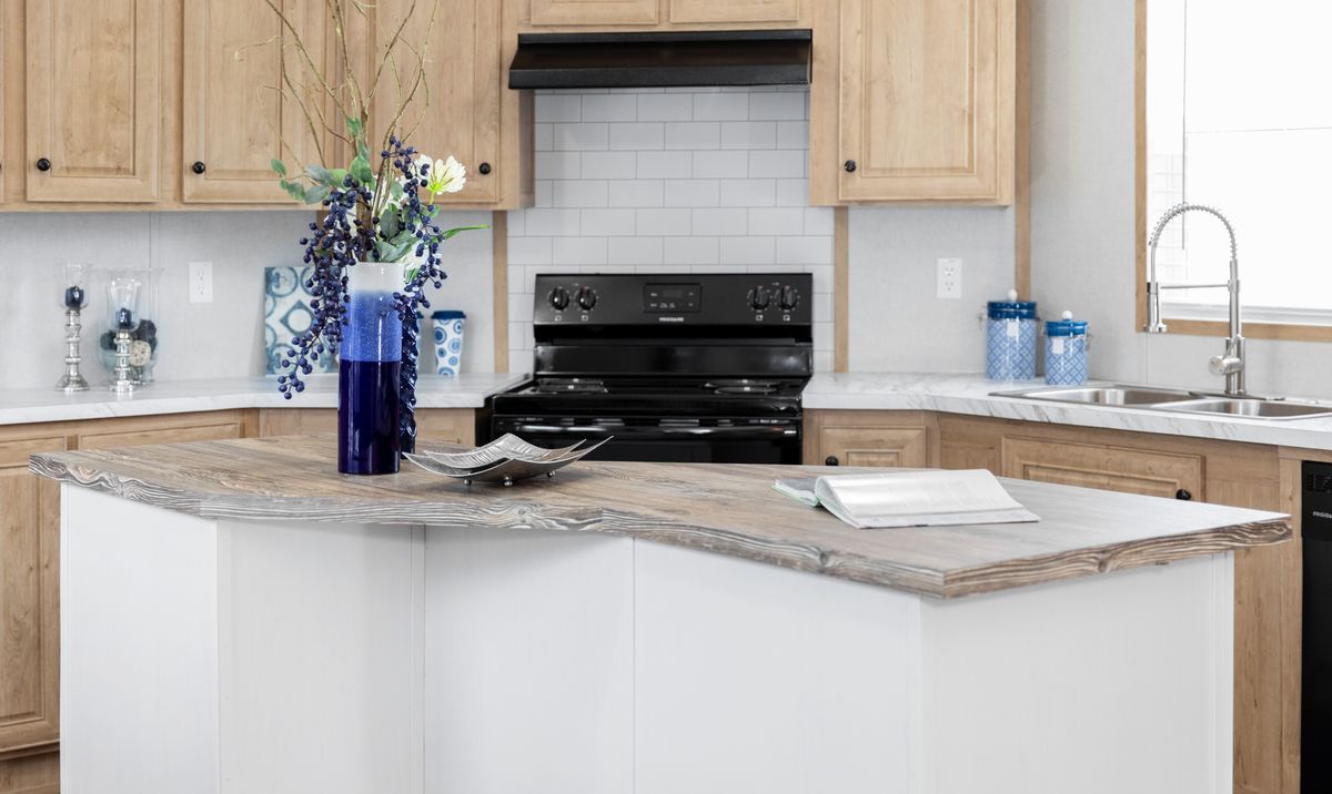 5963aa0c-86ee-4f01-a8d9-a3aa005b354d A kitchen with white cabinets and wood counter tops.