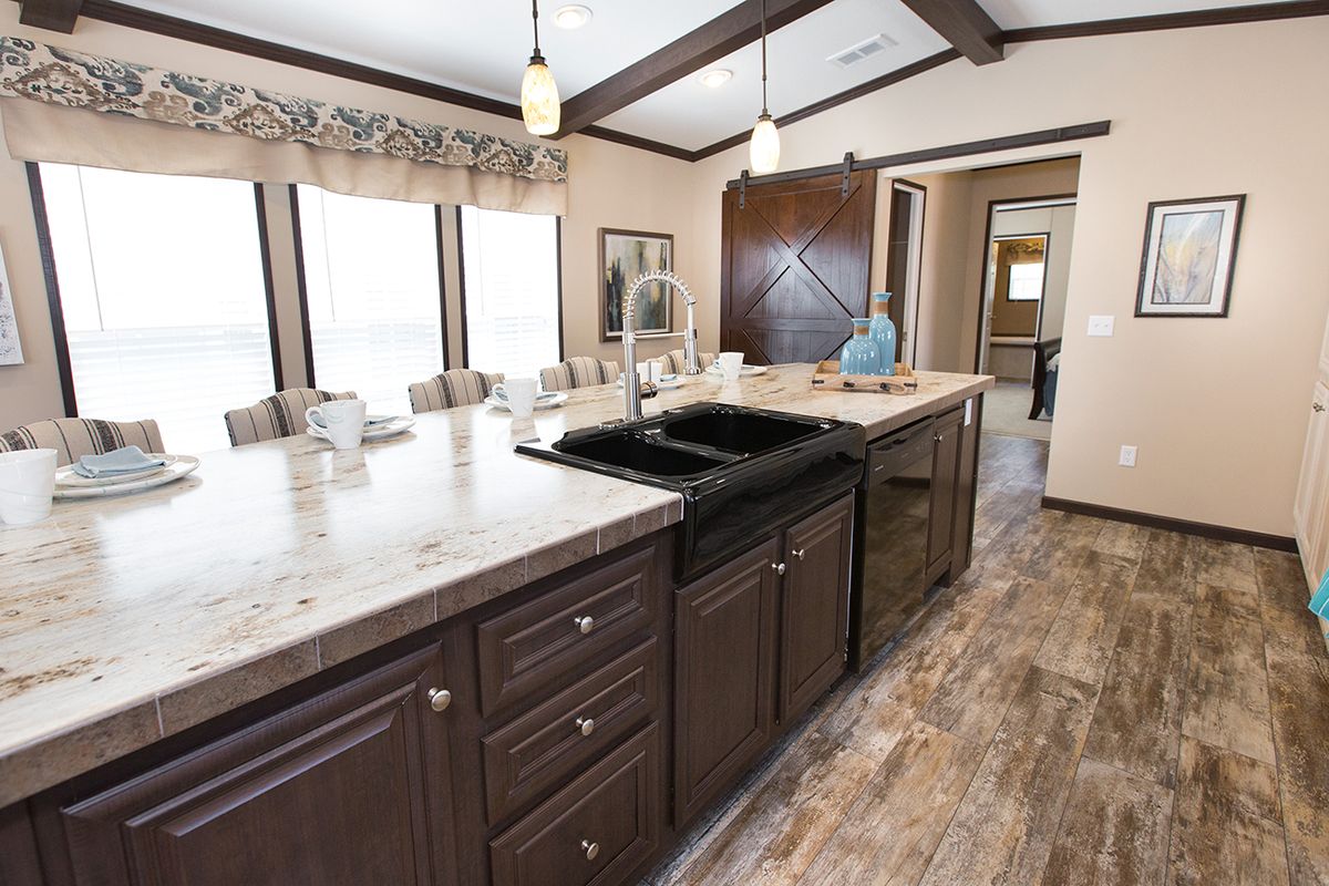 null A kitchen in a mobile home with hardwood floors.