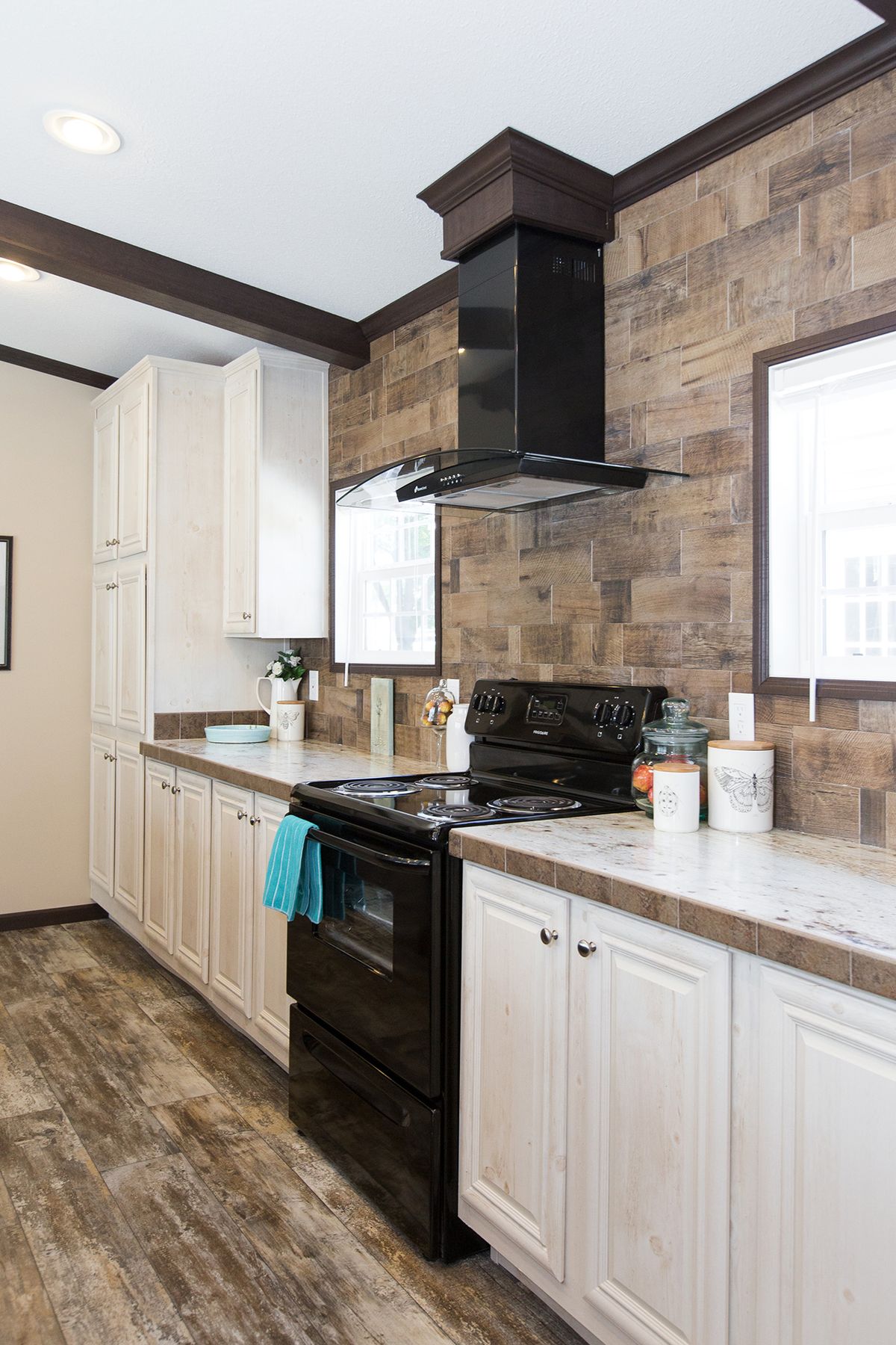 null A kitchen in a mobile home with wood floors.