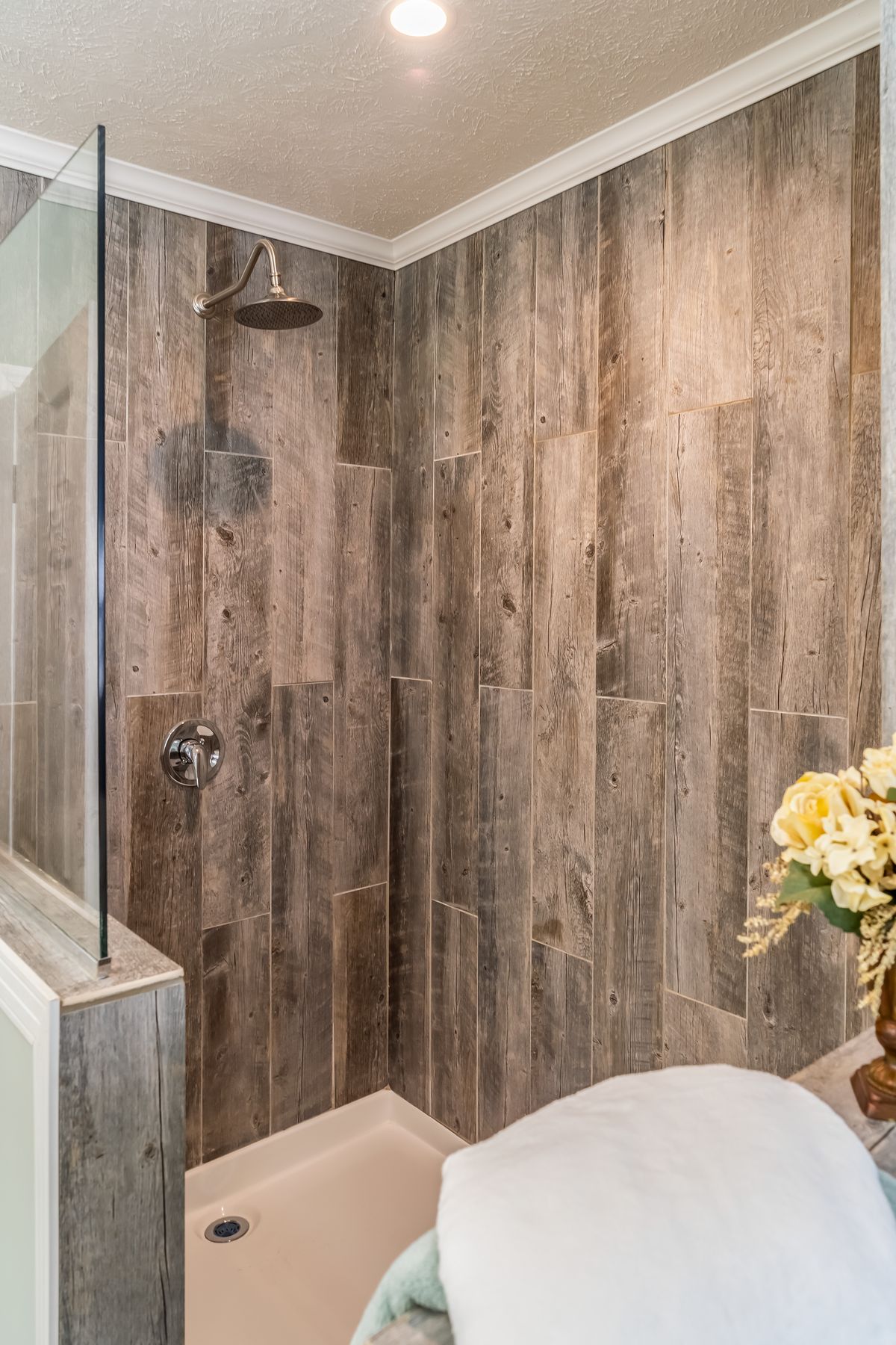 5ab1b065-f384-4906-b9e3-f2849f2cf179 A bathroom with wood walls and a glass shower.