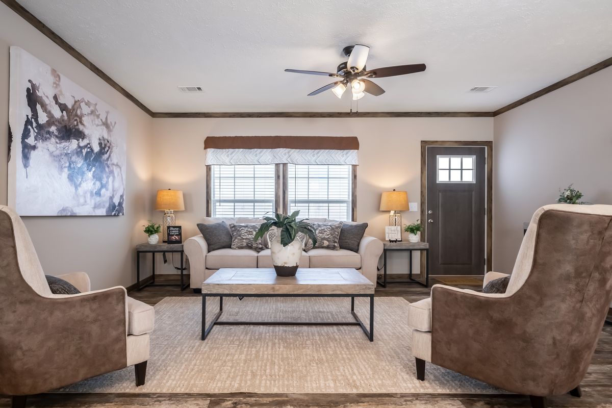 A living room in a mobile home with a ceiling fan.