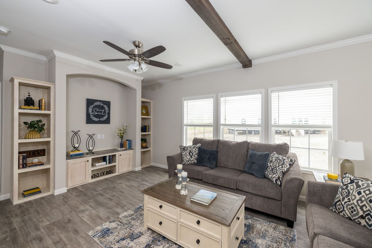 5e442154-6d0b-4642-87ad-502773b732dc A living room with couches and a ceiling fan.