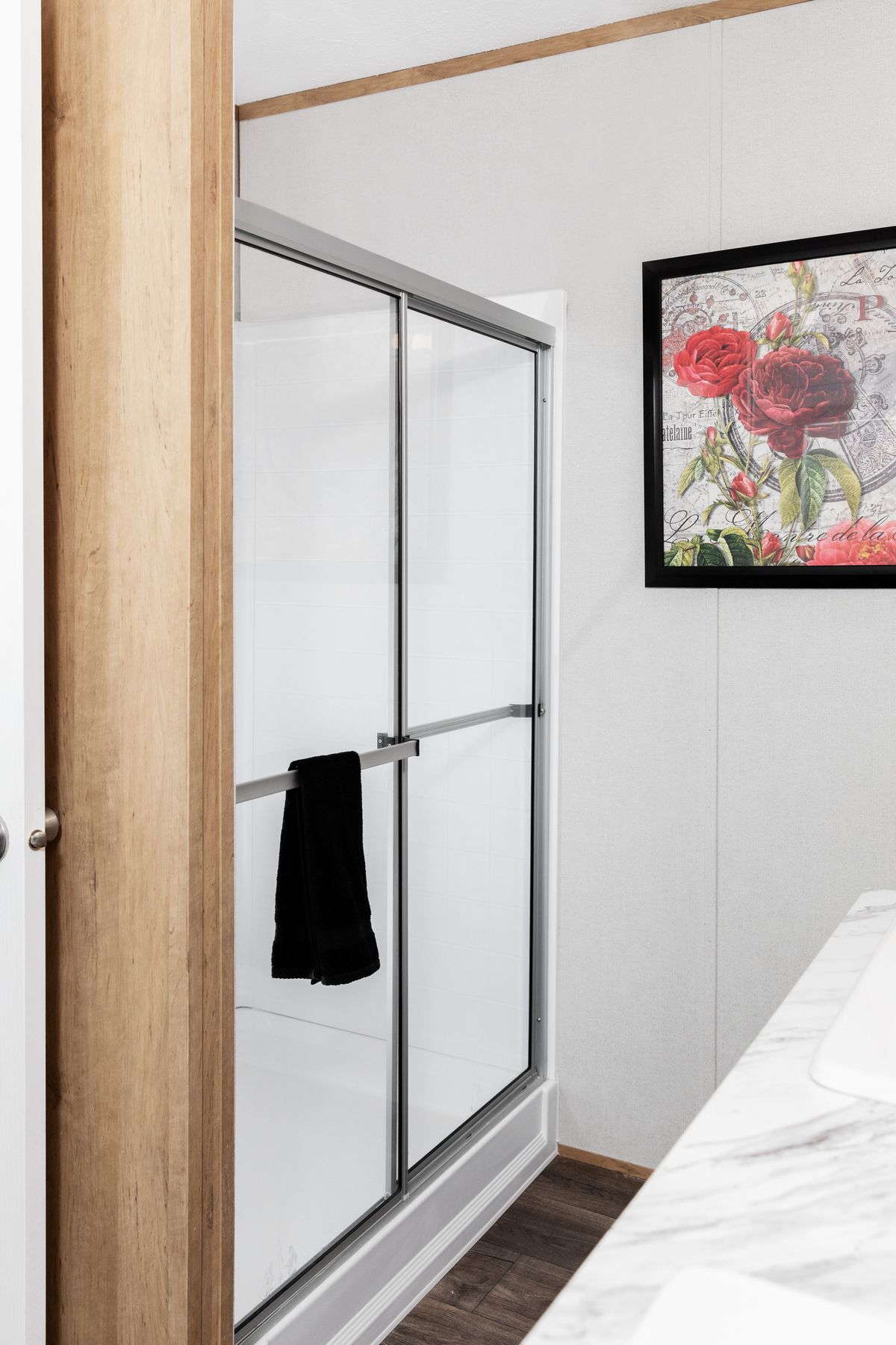 61ac0206-0dd4-42cd-a91a-f12c45c48fdb A bathroom in a mobile home with a walk in shower.