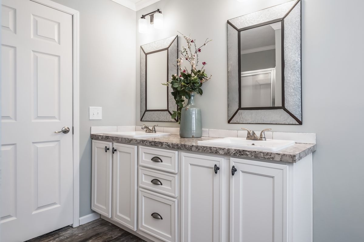 6639aba4-a4f5-406b-8ed8-eecb31296107 A bathroom with two sinks and mirrors.
