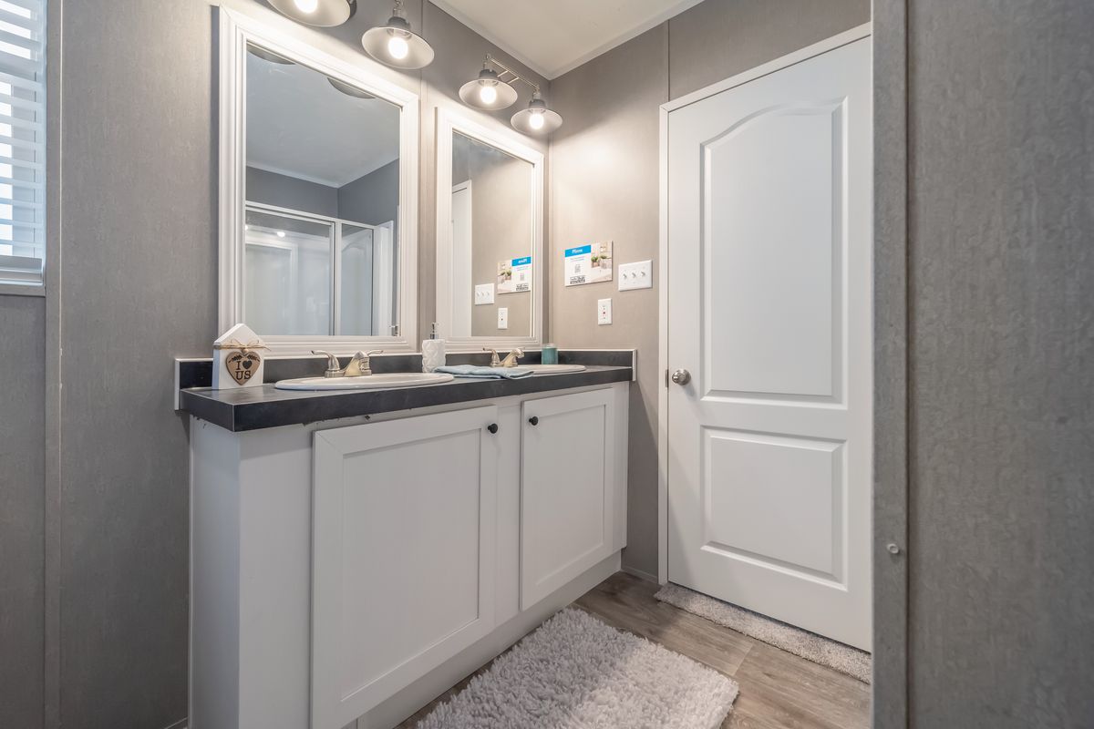 A bathroom with two sinks and a mirror.