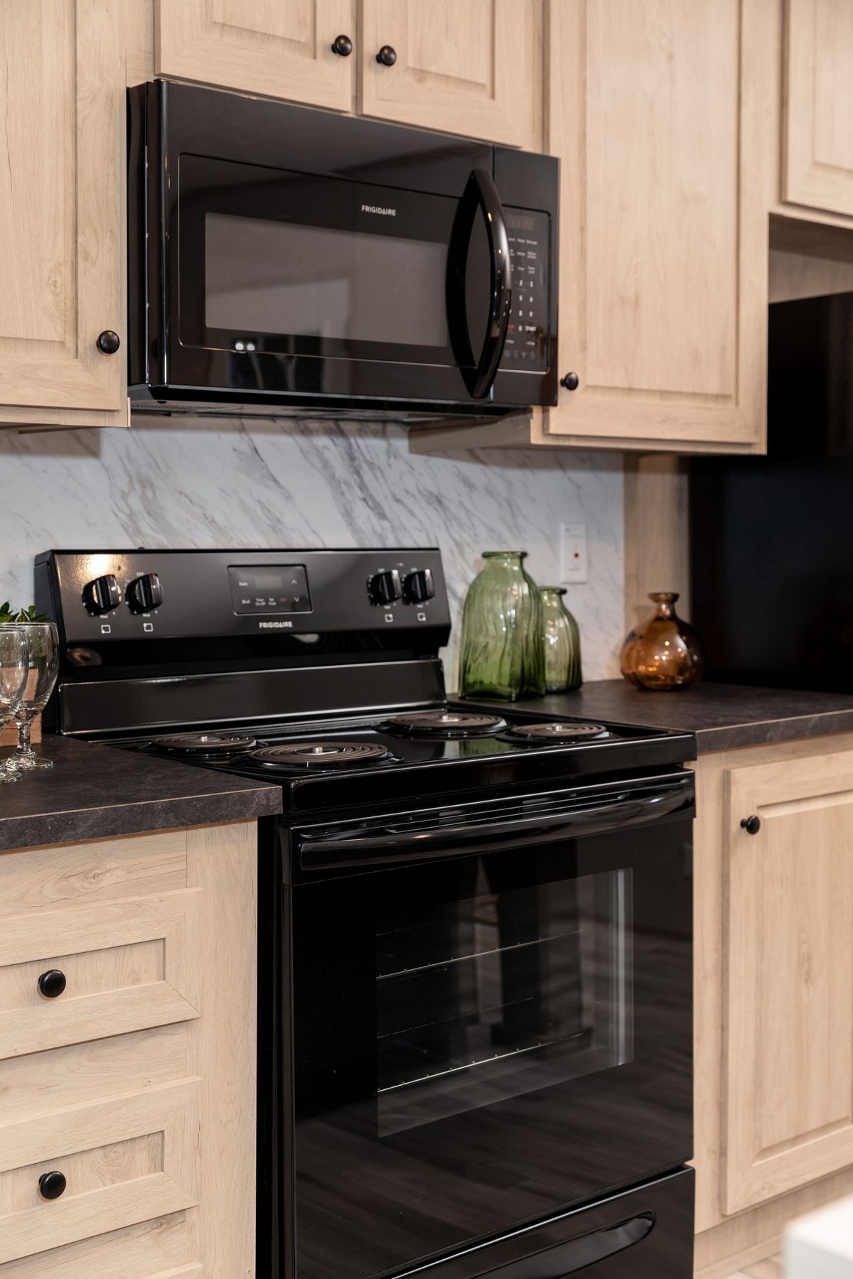 68de17fa-610a-4f4b-9b59-d4ac9e9f6ba8 A kitchen with black appliances and marble counter tops.