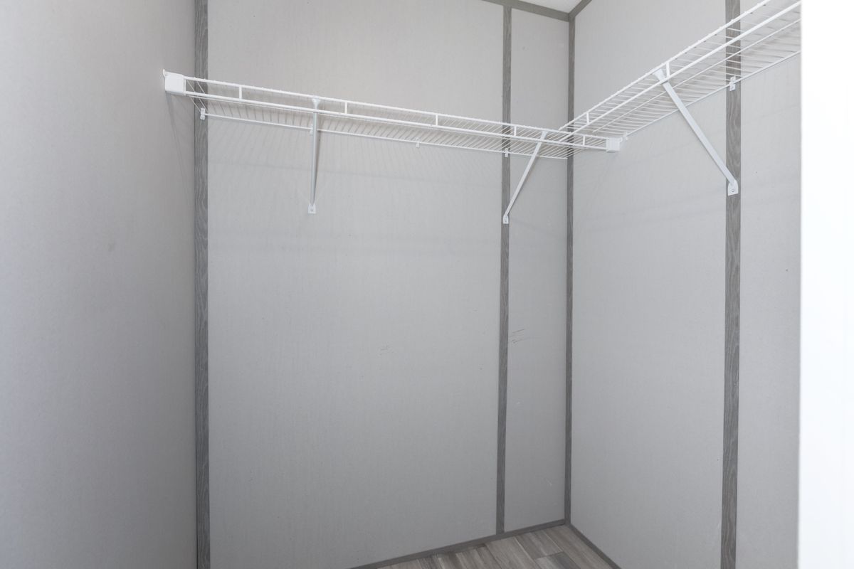 6a221211-de49-4830-acd7-22ea015c26f9 A closet in a small room with a wooden floor.