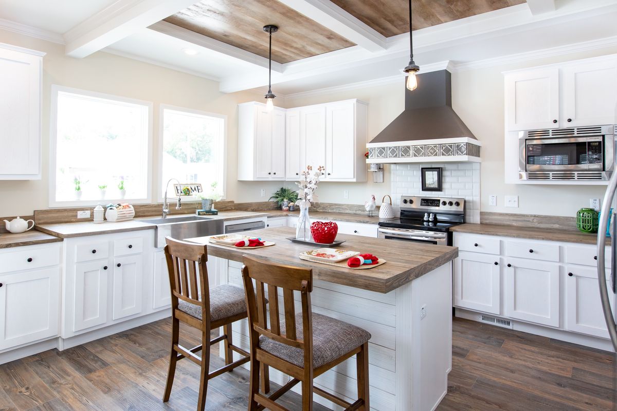 6cc2381c-3aab-4263-98df-1fbdbd5c6db3 A kitchen with white cabinets and wood floors.