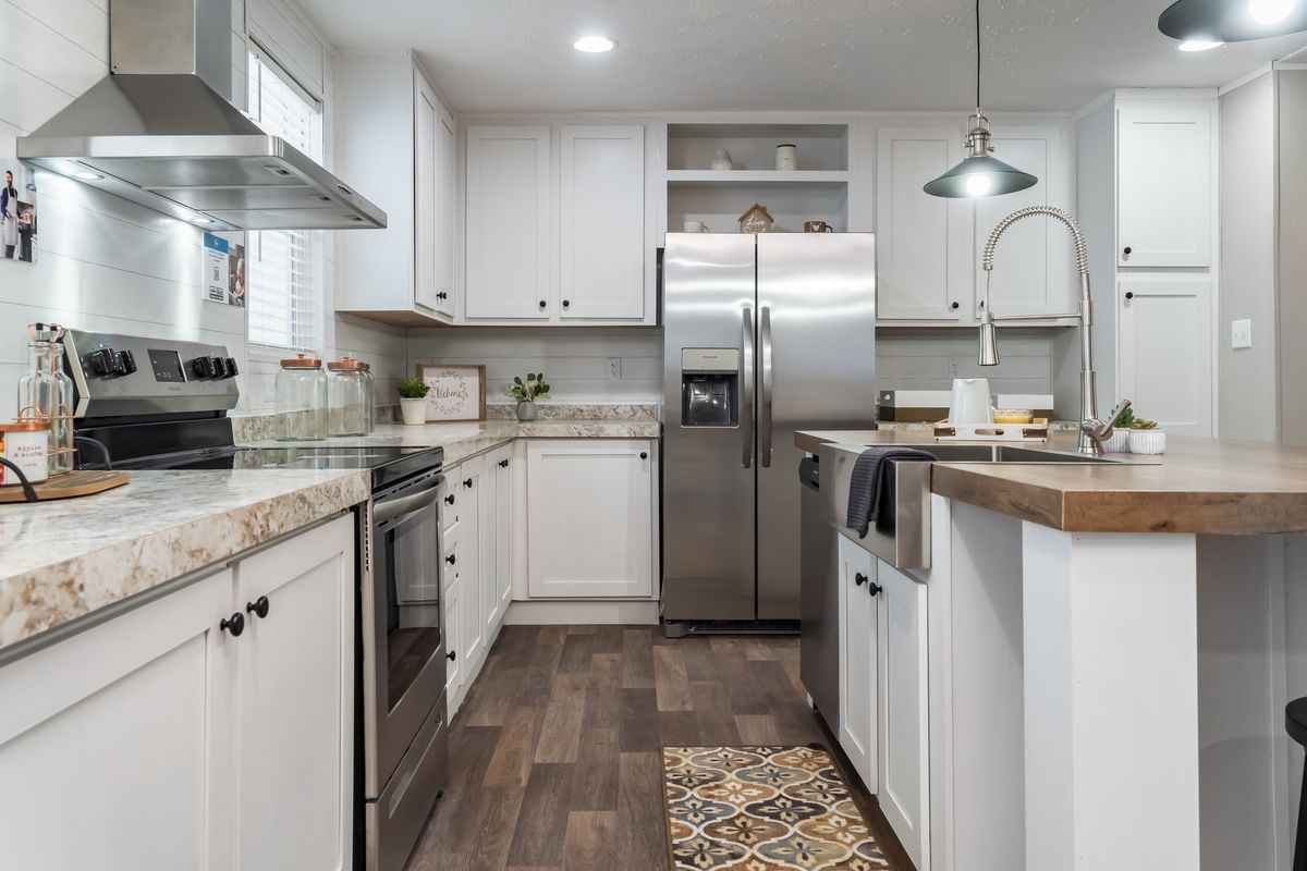 A white kitchen with stainless steel appliances.