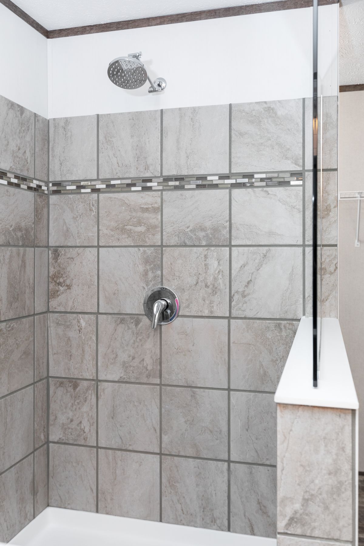 A bathroom with tiled walls and a shower.