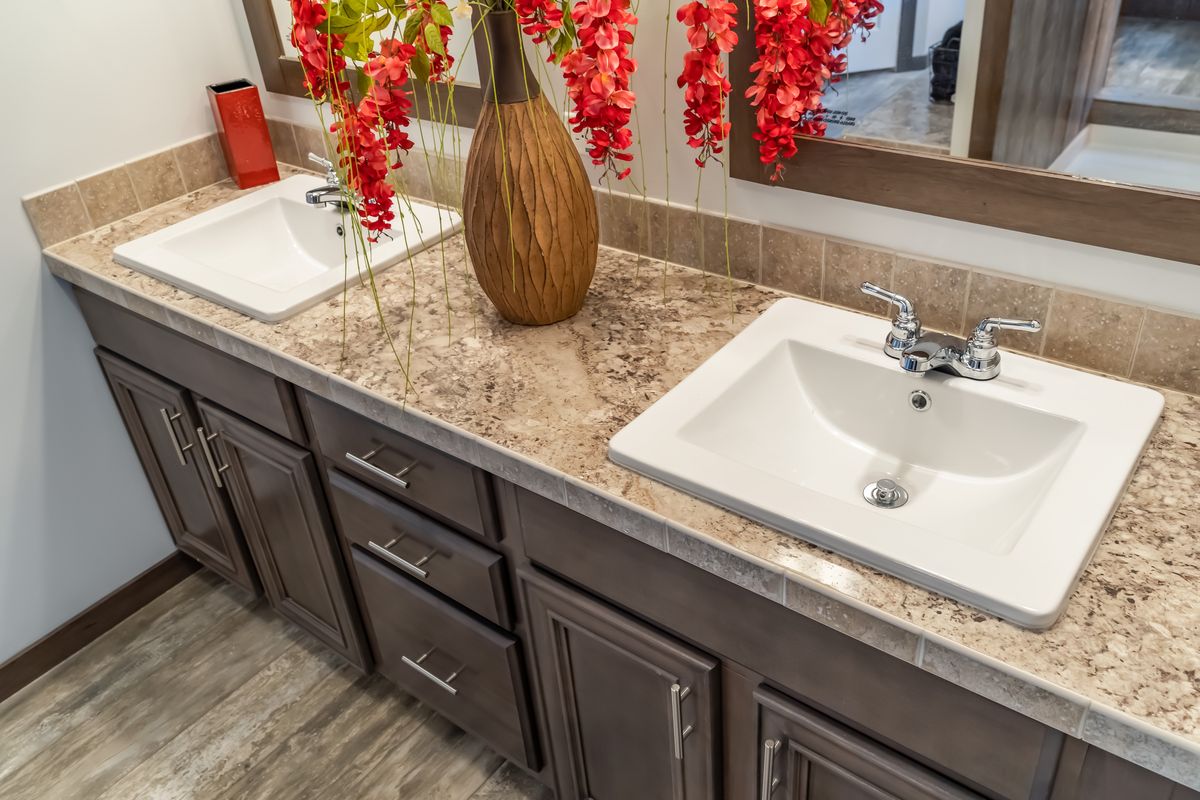 A bathroom with two sinks and a flower arrangement.