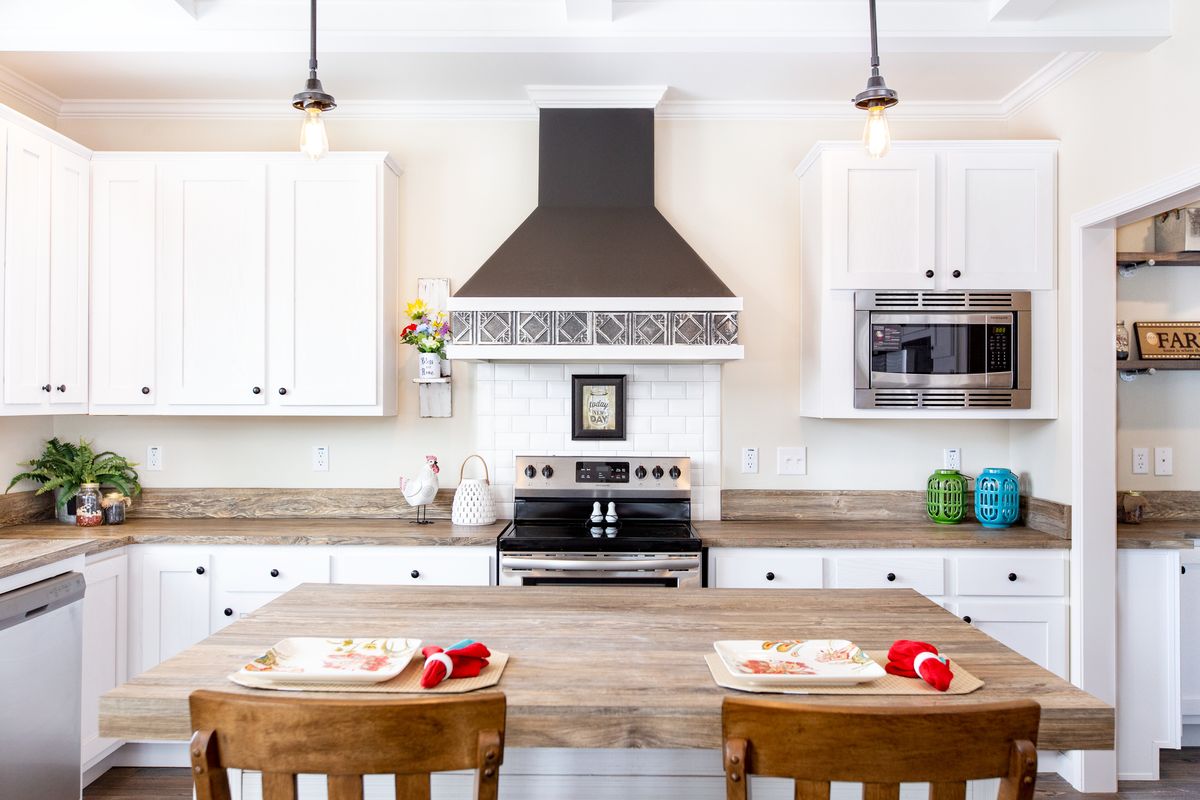 72095590-2f87-41c7-aef9-bae9f236a068 A kitchen with white cabinets and wood counter tops.