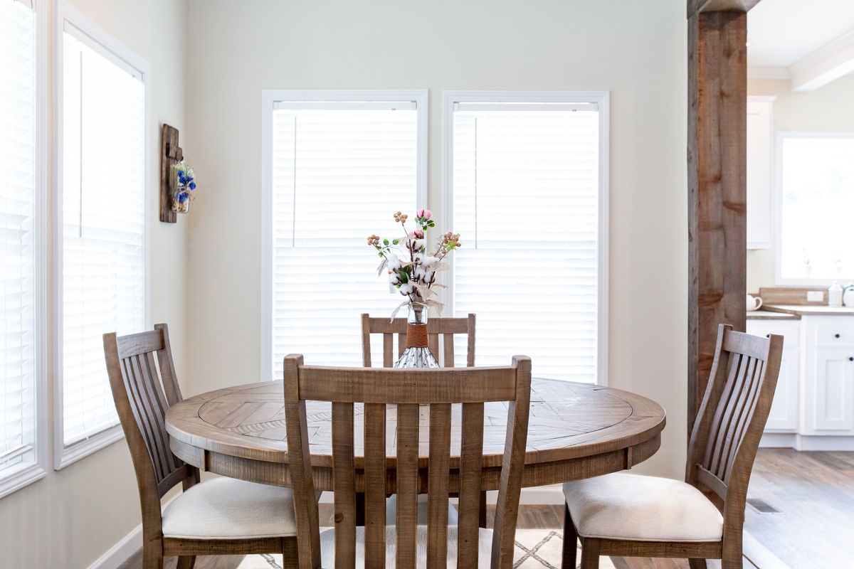 724712ea-8a07-47f9-86ca-ca347057013b A dining room with a wooden table and chairs.