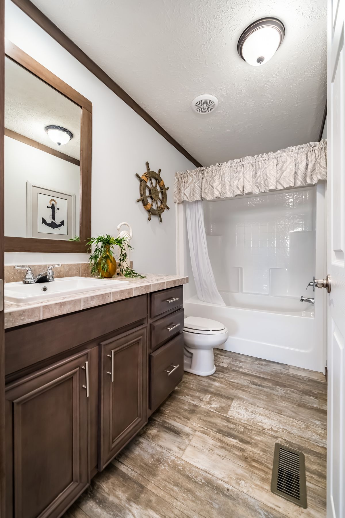 A bathroom in a mobile home with a sink and toilet.
