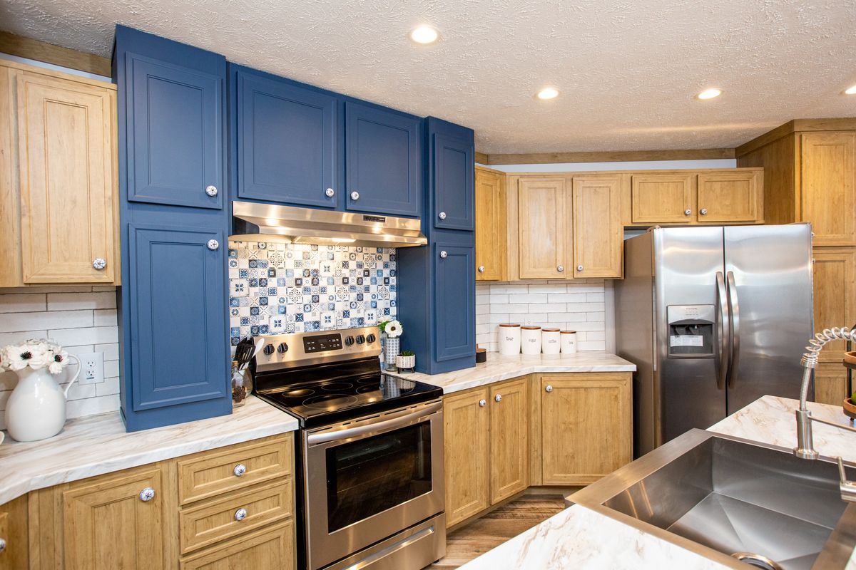 A kitchen with blue cabinets and stainless steel appliances.