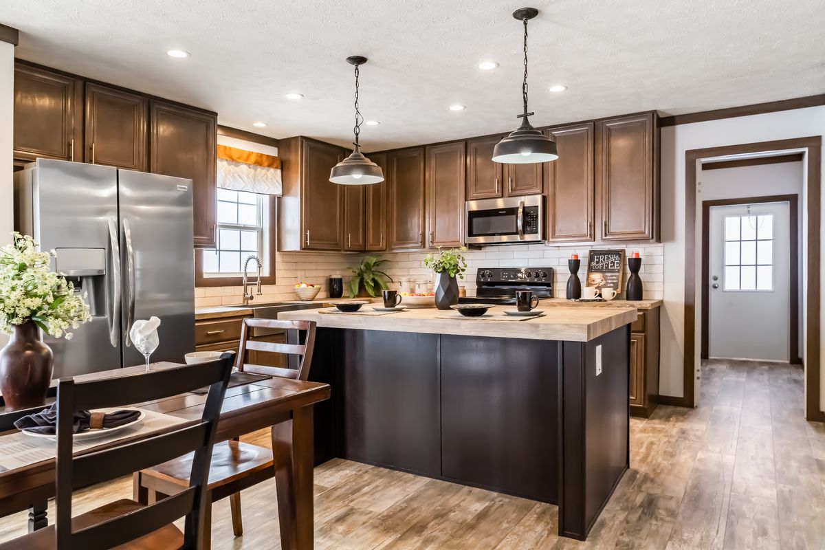 A kitchen with wood cabinets and stainless steel appliances.