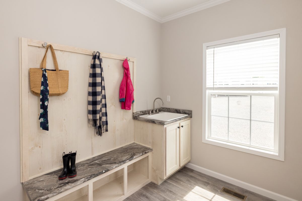 74b56092-7b31-48a8-9533-18caa3eed5ab A mudroom with a sink and coat rack.