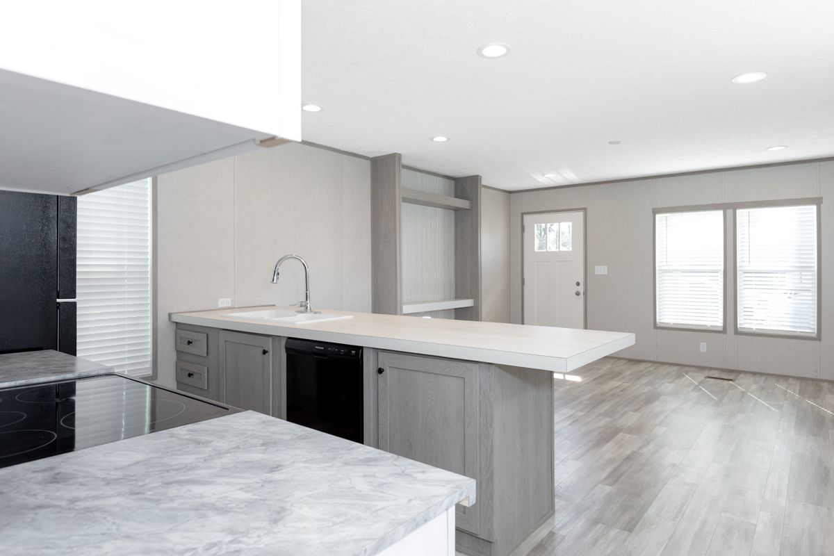 7693933b-68c2-43d3-b227-6e166fcfa96c A kitchen with white cabinets and marble counter tops.