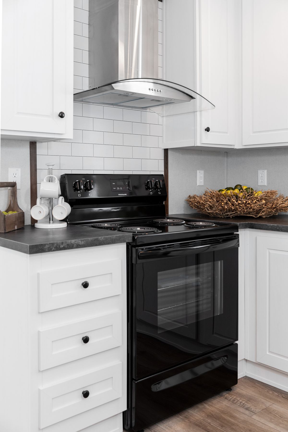 A kitchen with a black stove and white cabinets.