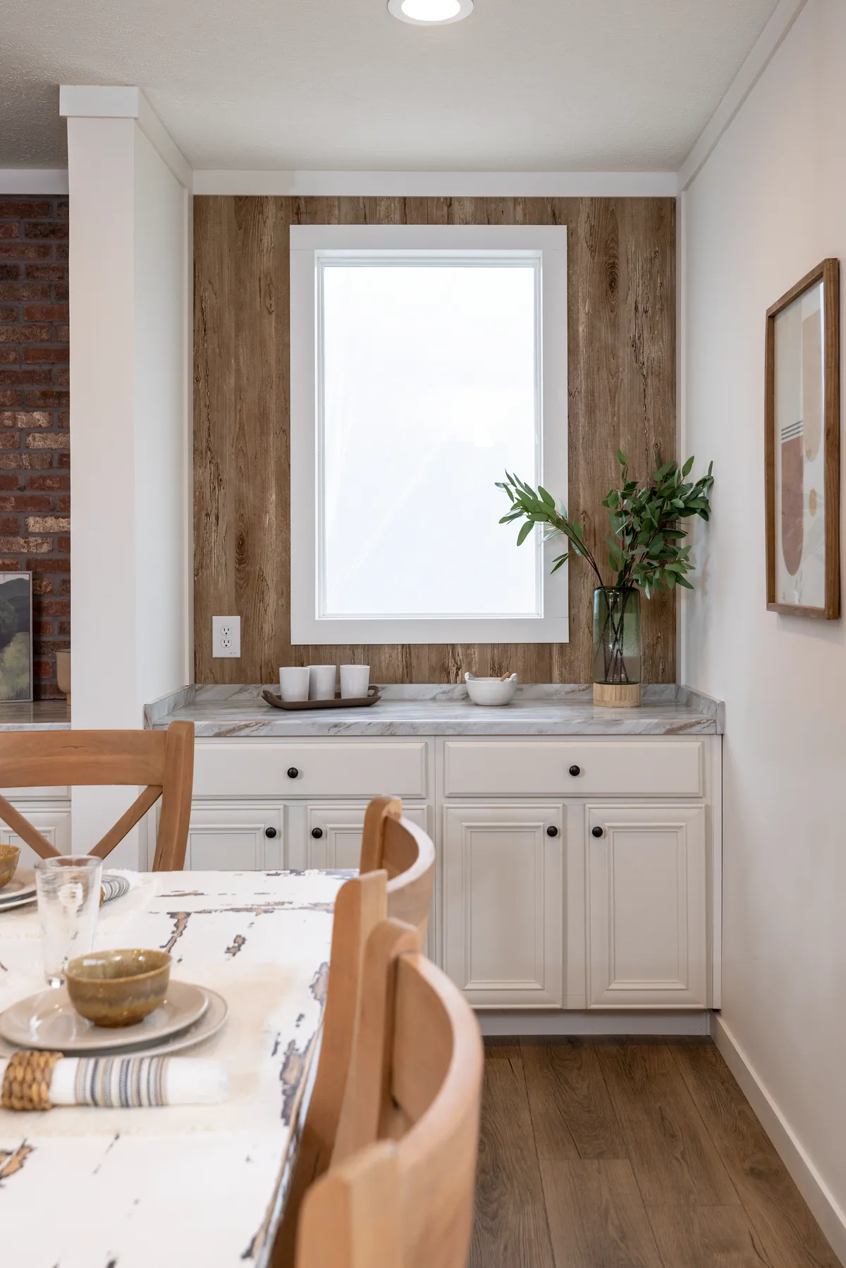 77fc030c-8711-4a26-8a95-60940599407b A white kitchen with wood paneling.