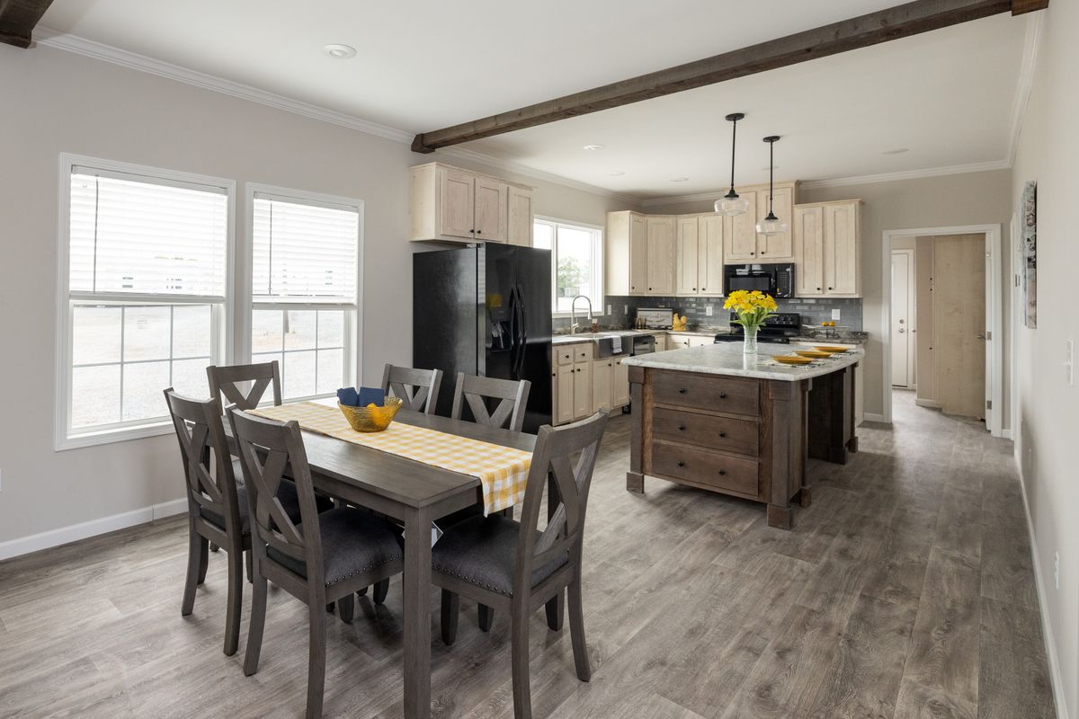 7b60a971-8a4a-4af7-9d4b-ec27c3693710 A kitchen with hardwood floors and a dining table.