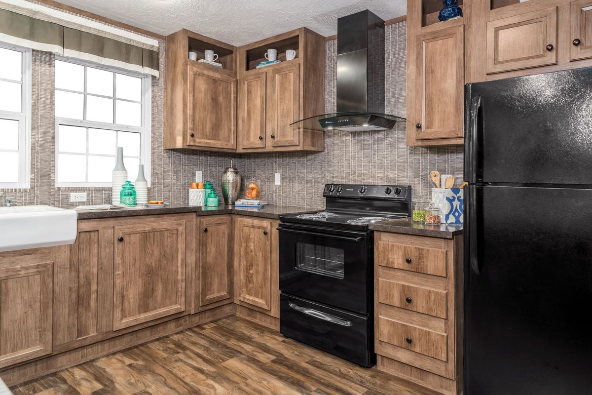 A kitchen with wood cabinets and black appliances.
