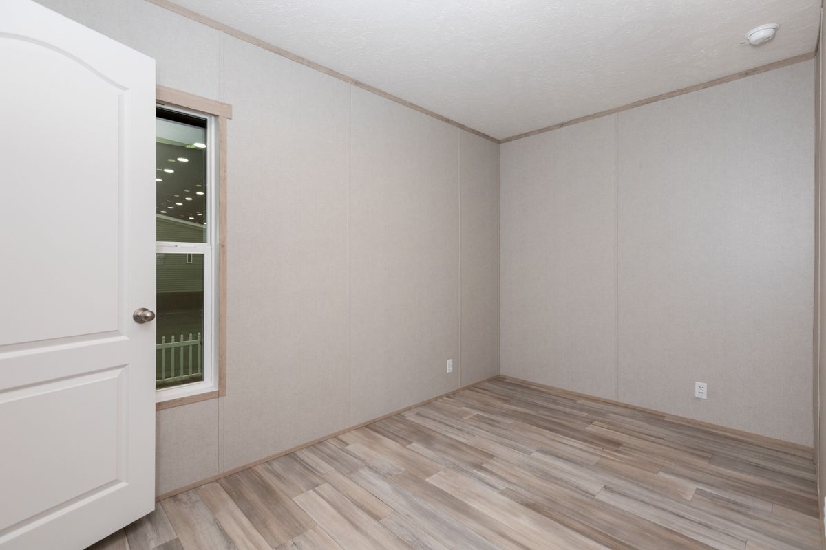 7c64a929-a40b-4361-b6df-4b45f9de3a4c An empty room with wood floors and a door.
