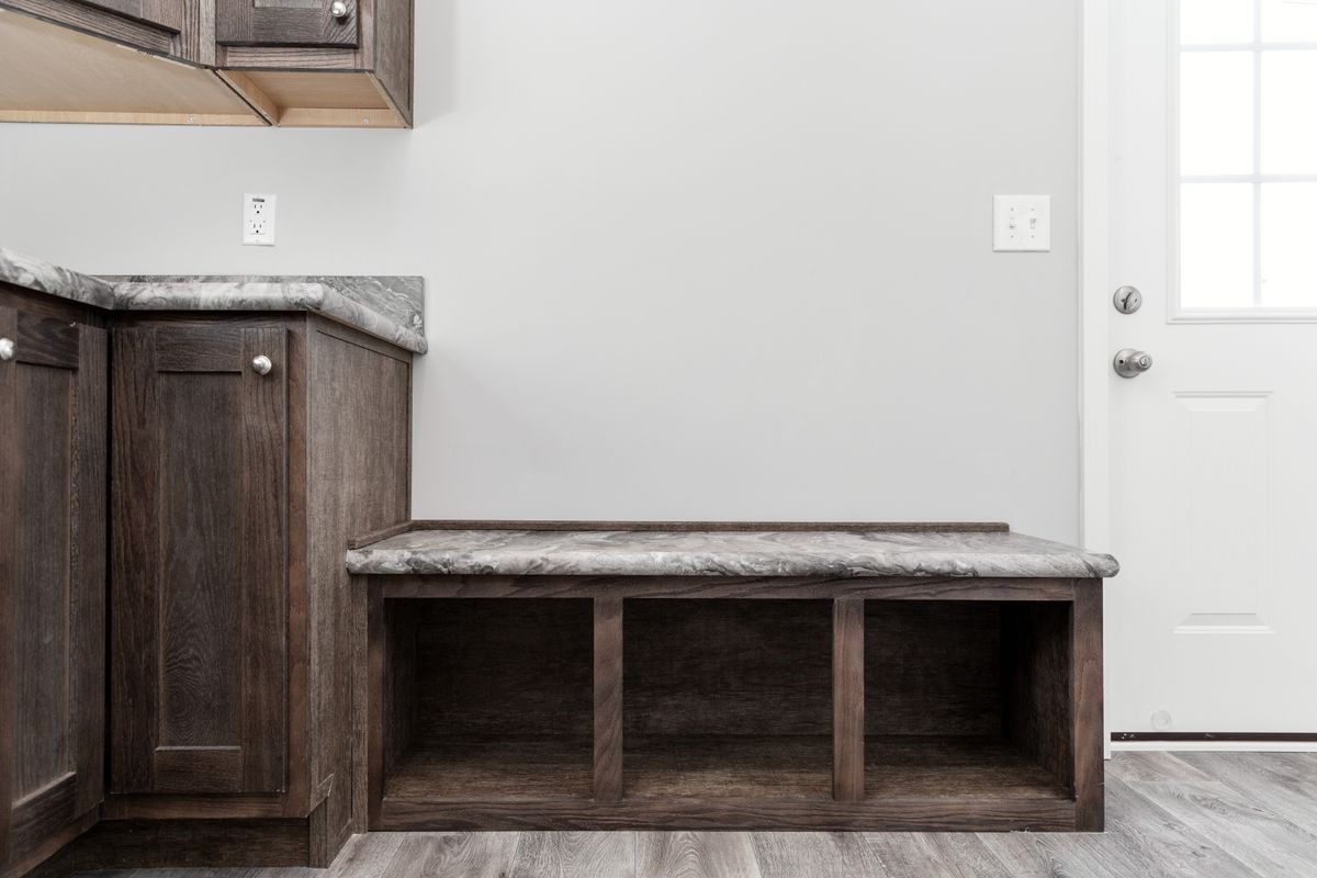 7d3afca7-d618-4259-8a91-38768f35bde9 A small kitchen with a bench and cabinets.