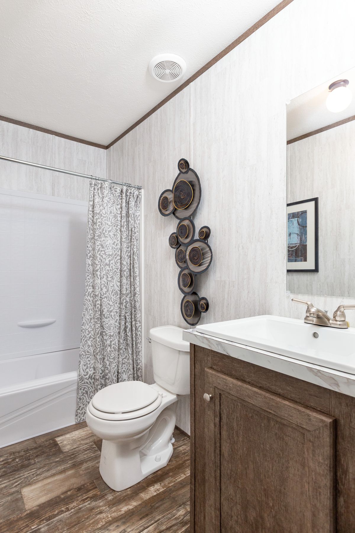 7f9deb58-1e3d-410e-811e-585911bfa874 A bathroom with a toilet, shower, and sink.