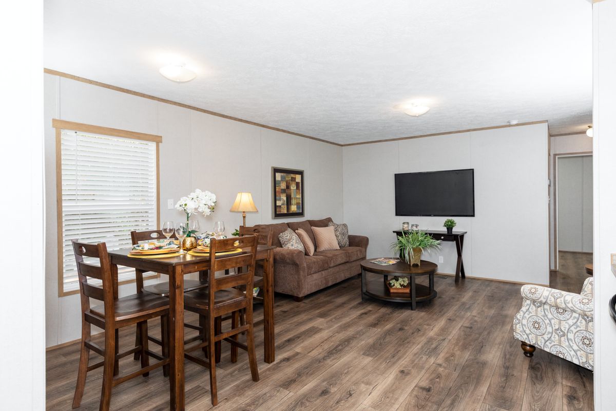 A living room and dining room in a mobile home.