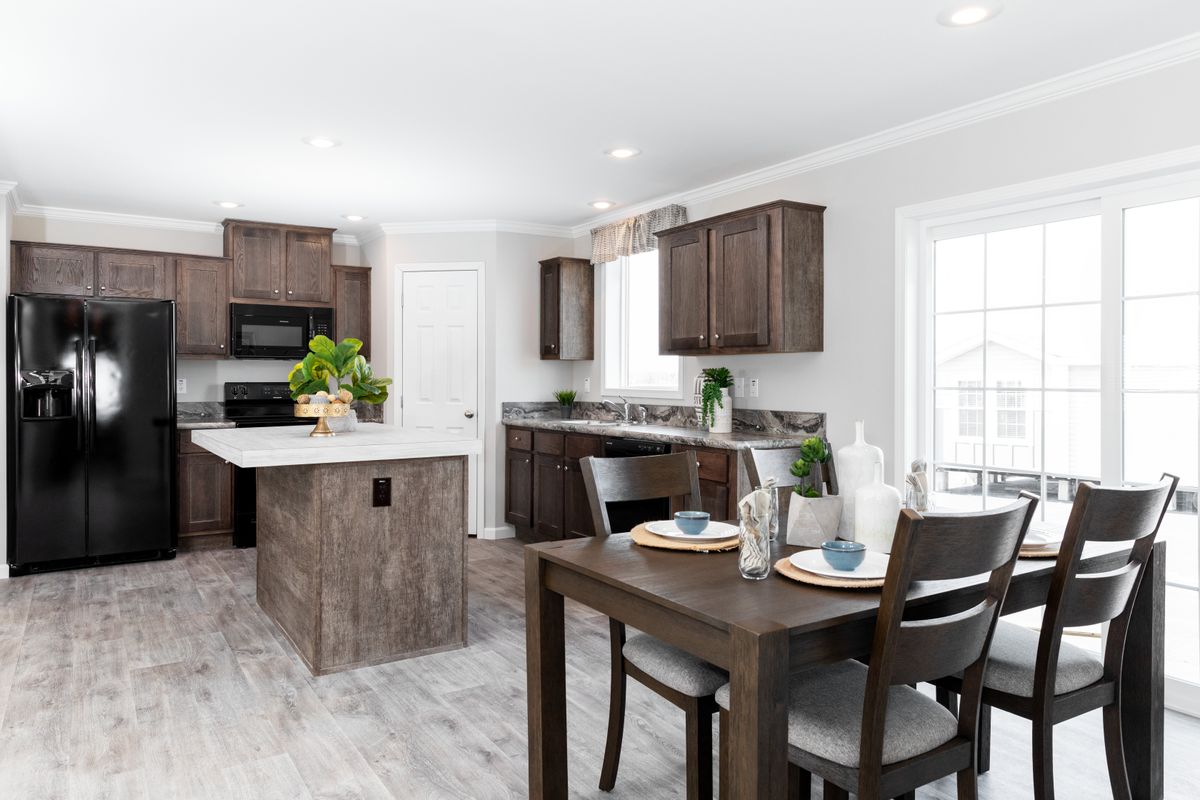 8302b2eb-1a0b-4ac1-b92c-cf87faa6b0f3 A kitchen with wood cabinets and a dining table.