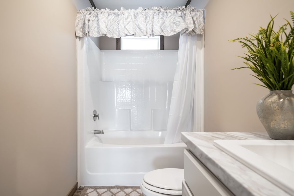 A white bathroom with a toilet and shower.