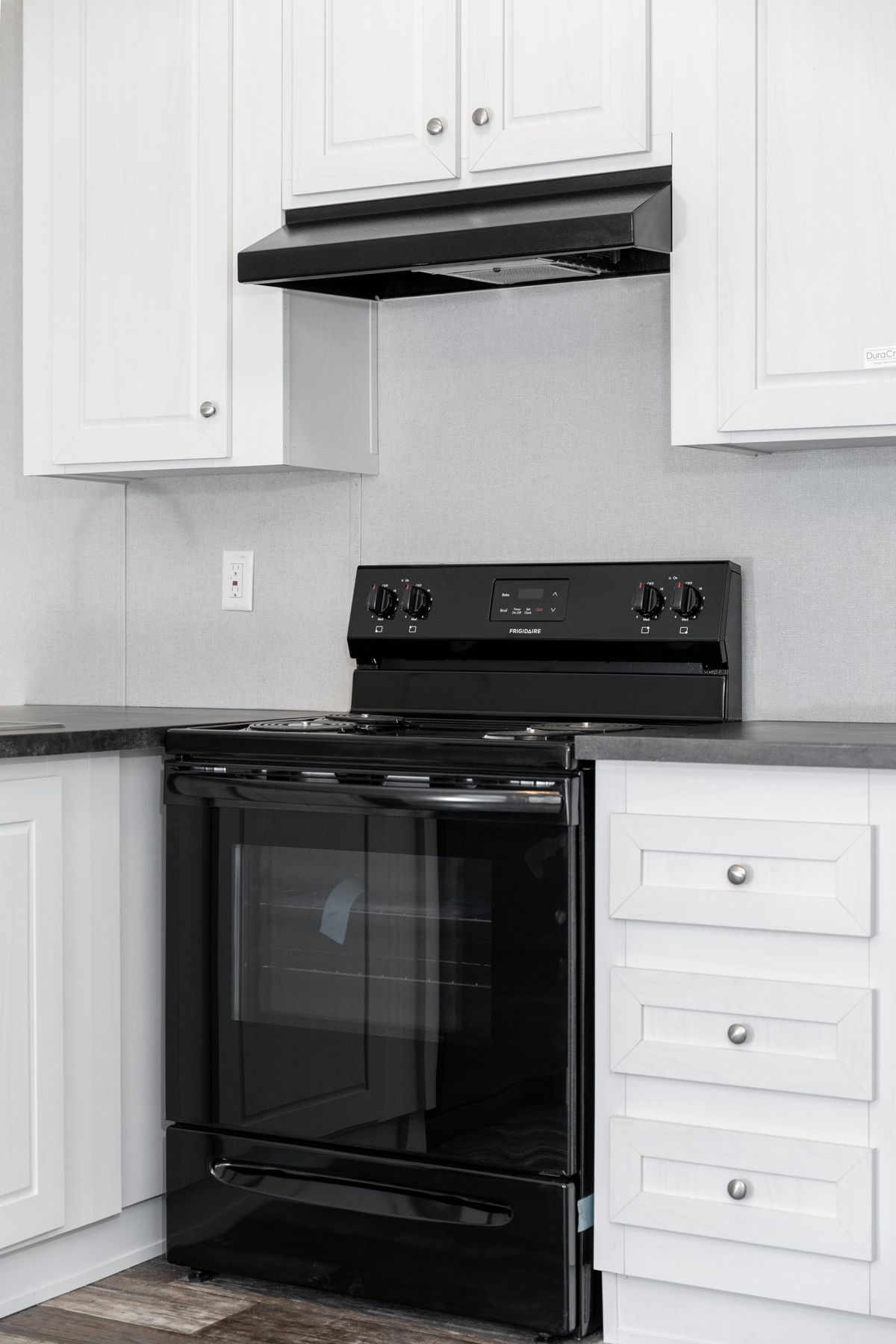 87329774-63d5-4a21-bb57-b4c8e56261c5 A kitchen with black appliances and white cabinets.