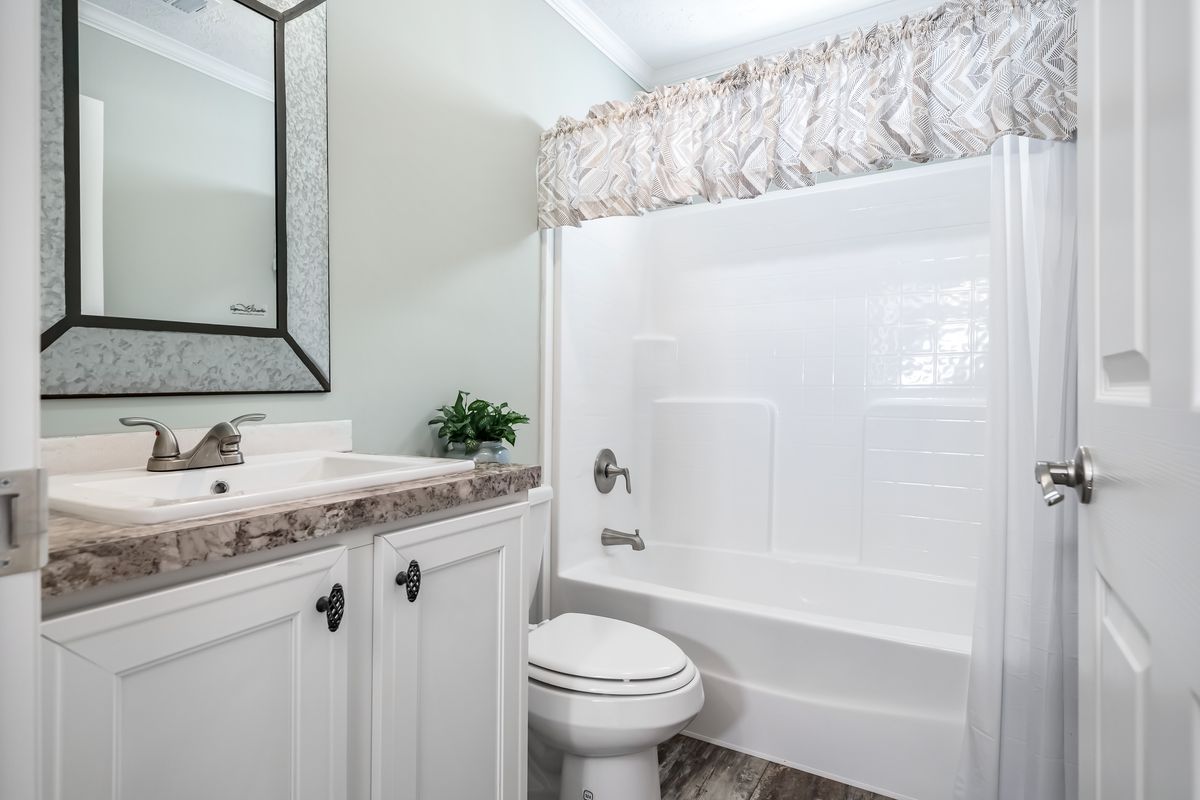 8e05b203-07e3-4e37-ad90-3b7e93b8eafa A white bathroom with a toilet and shower.