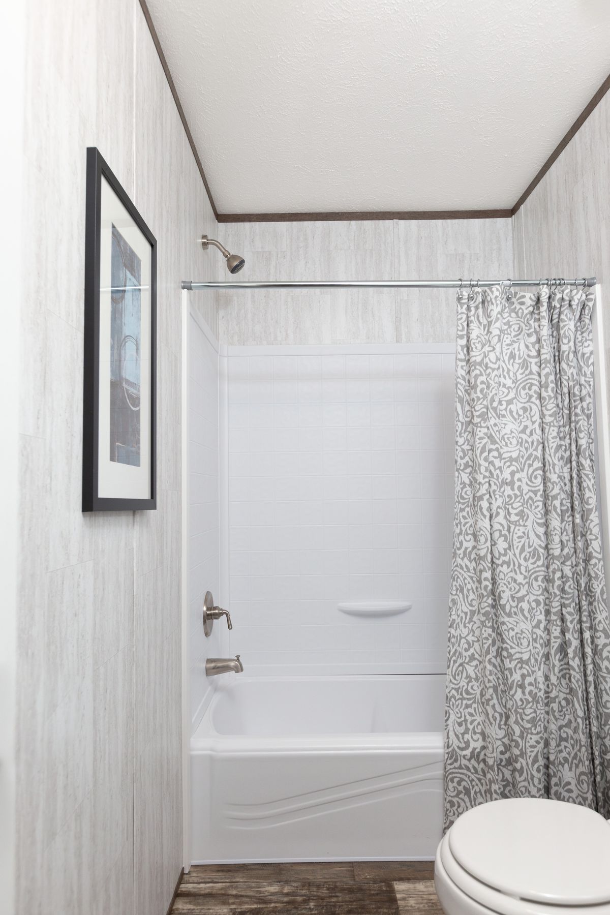 9106dc4a-d658-4fec-9ea7-5ec5a07cb0f4 A small bathroom with a toilet and shower.