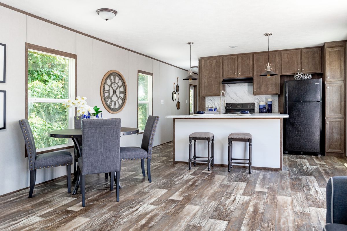 91746fe7-d1b2-4198-be99-24e49a256b26 A kitchen and dining room in a mobile home.