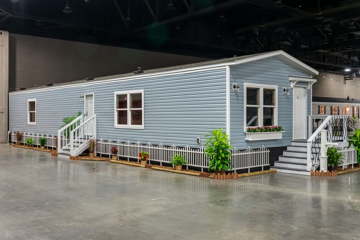 94b4a9f0-6273-451a-9143-8e72b5a913df A blue mobile home in a showroom.
