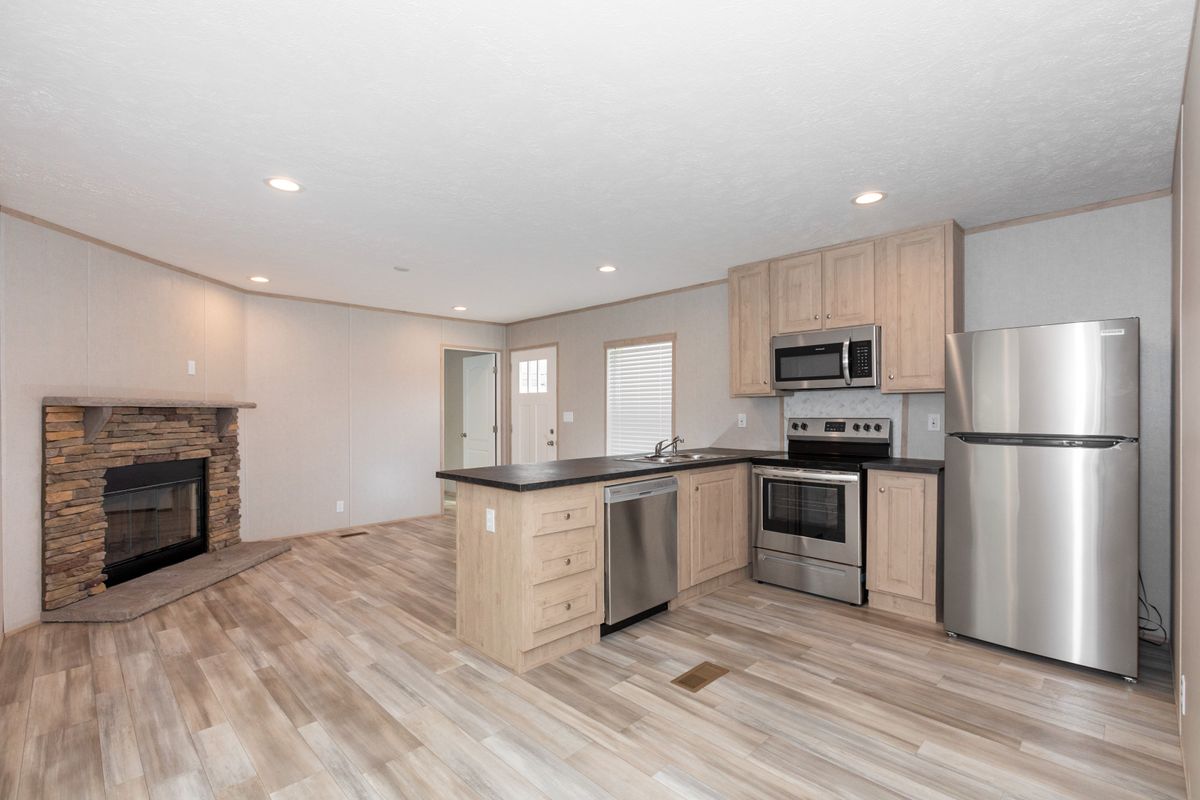 969d55b7-0039-4aef-8cb1-37cff094a55c A kitchen with stainless steel appliances and a fireplace.