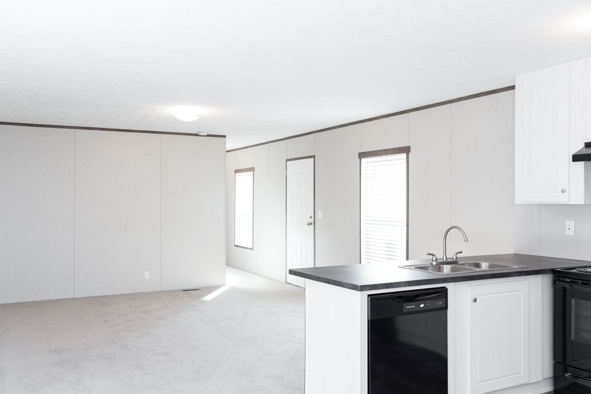 99dbae14-517c-4bc8-9667-df92f5f9d371 A white kitchen with a black stove and refrigerator.