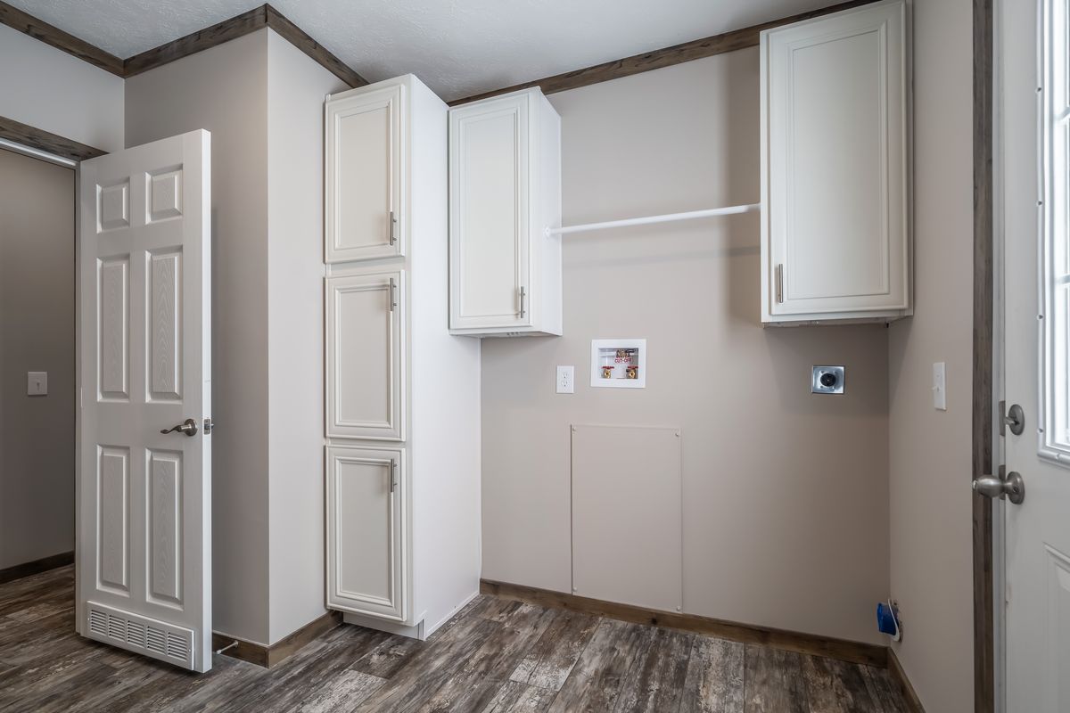 A room with white cabinets and hardwood floors.