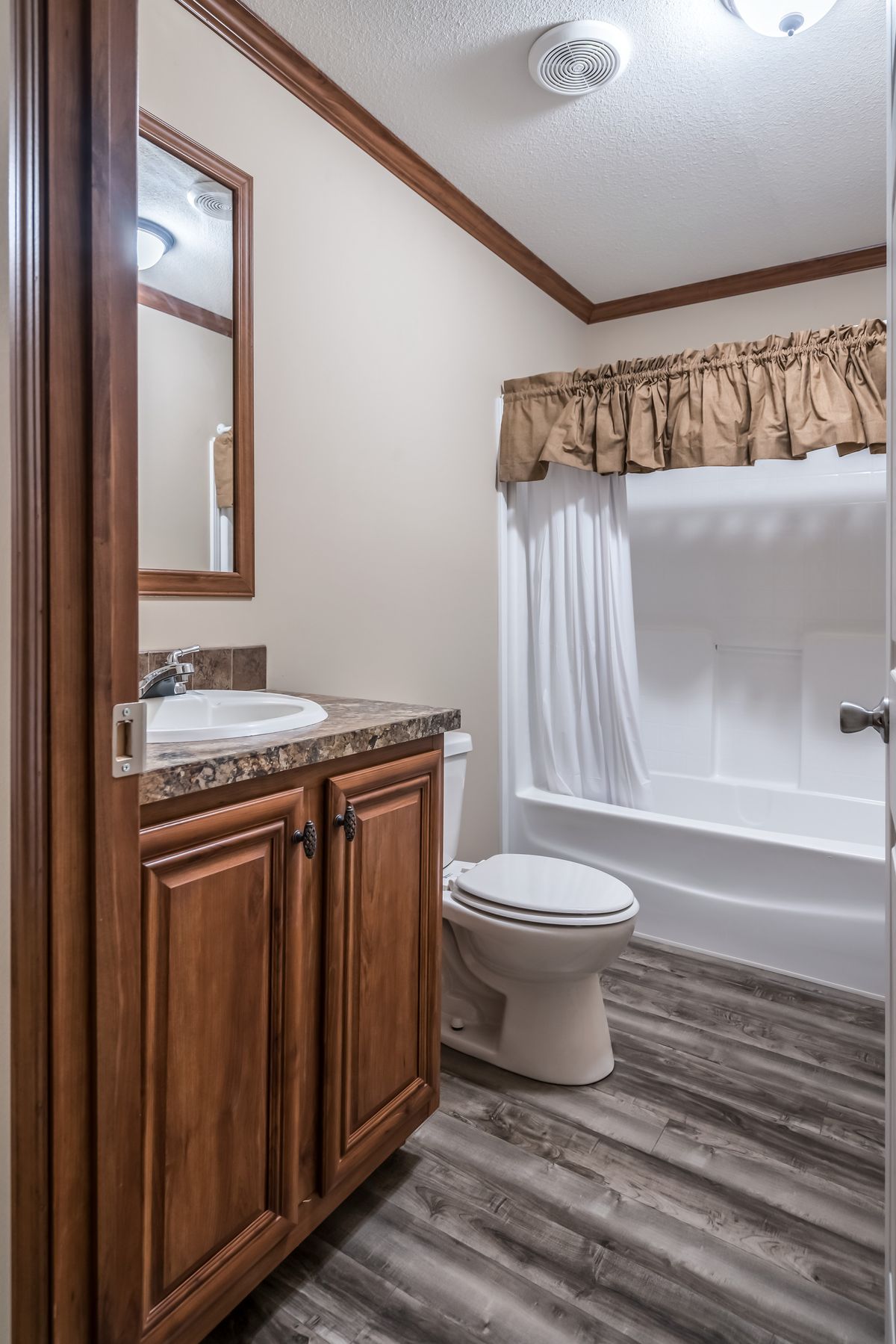 A bathroom with a toilet, sink and shower.