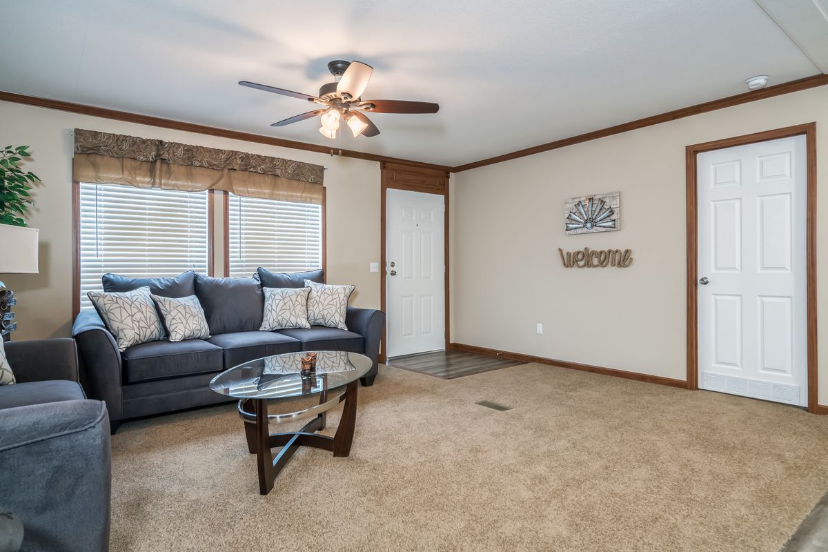 A living room in a mobile home with a ceiling fan.