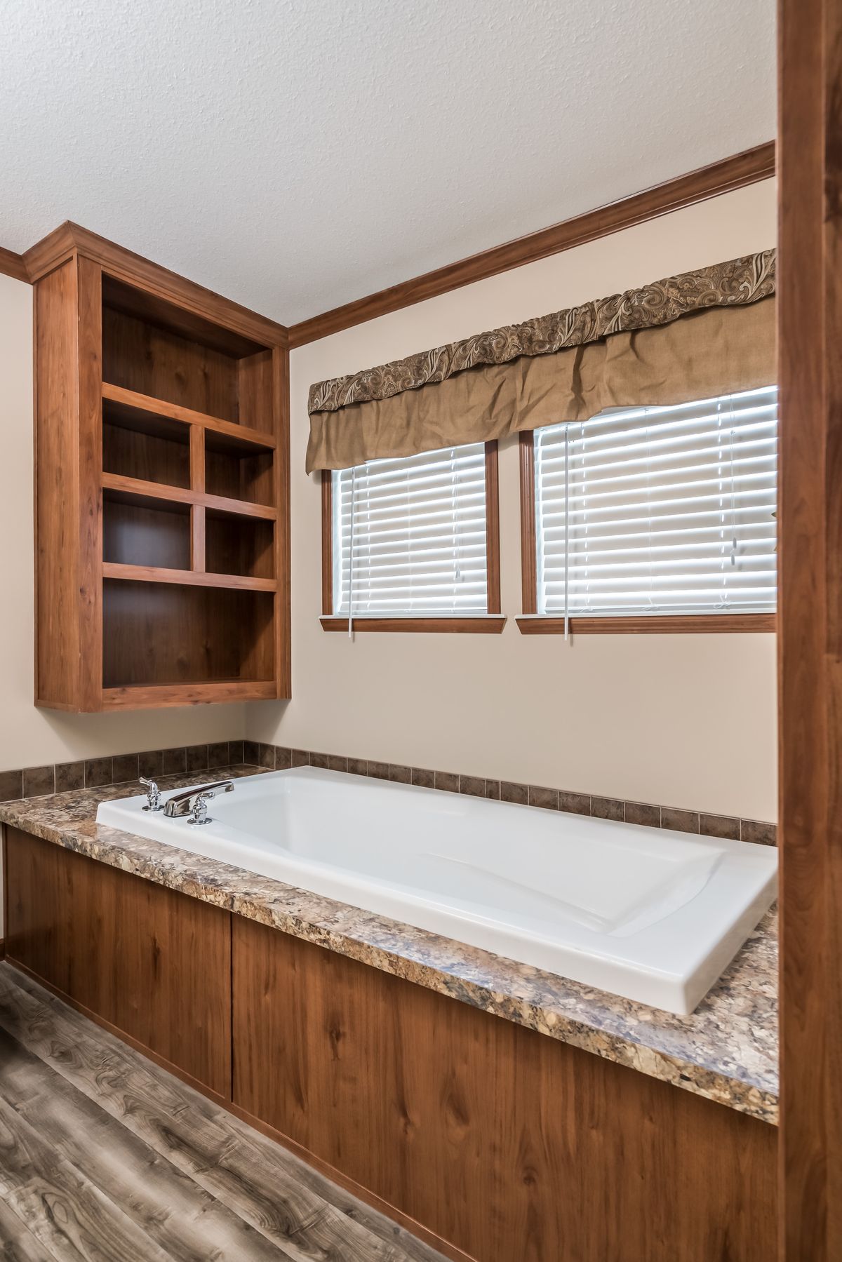 A bathroom with a tub, sink and cabinets.