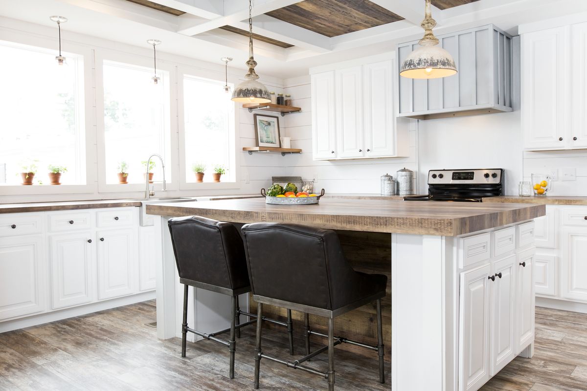 A white kitchen with wood floors and a center island.